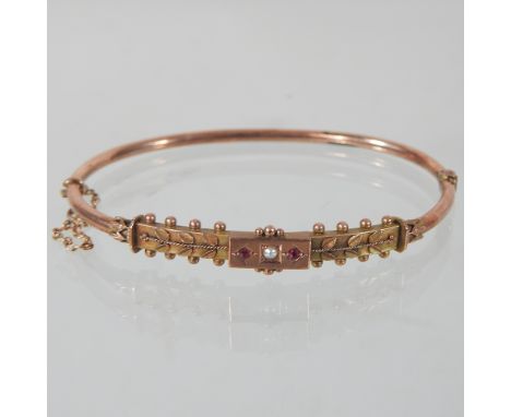 An unmarked Victorian ruby and seed pearl set bangle, of rose gold colour 