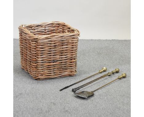 A wicker log basket, 52cm, together with a collection of brass fire tools