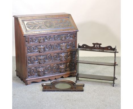 An early 20th century carved oak bureau, 91cm, together with a mahogany wall shelf and a coat rack