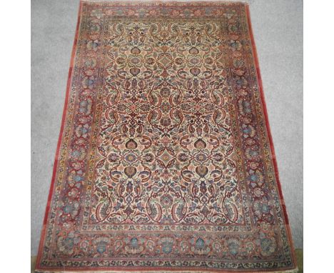 A Persian style woollen carpet, with floral designs on a red ground, 325 x 218cm