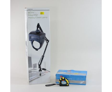 A table magnifier lamp, boxed, together with a box of tape measures