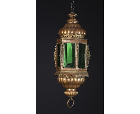 An 18th Century Italian Gilded Sheet Copper Lantern with a hexagonal body of green glass panes between a gadrooned repoussé t