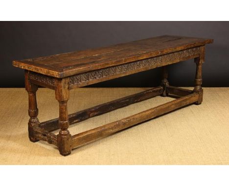 A 17th Century Oak Refectory Table (A/F).  The planked top with cleated ends on foliate carved frieze rails and columnar legs