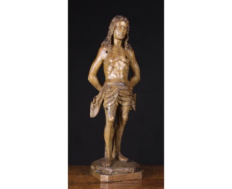 A Fabulous 16th Century Franco Flemish Oak Sculpture carved in the round with Saint Sebastian depicted with long wavy hair, t