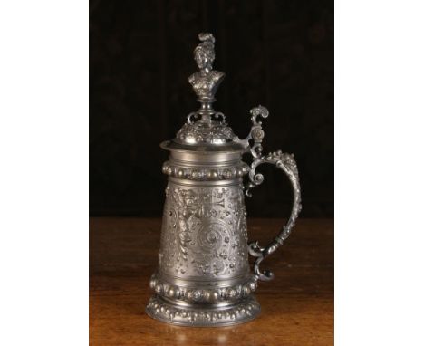 A Large & Decorative Renaissance Style Pewter Tankard with intricately cast ornamentation. The domed lid surmounted by a fema