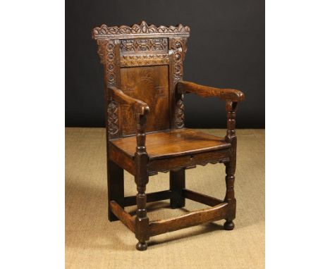 A 17th Century & Later Carved Oak Wainscot Chair. The shaped cresting rail,  shallow upper back panel and uprights enriched w
