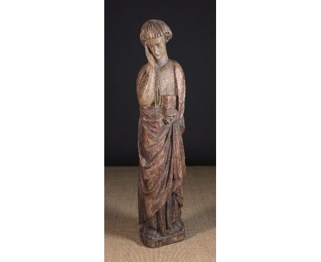 A Large 13th Century Polychromed Wood Carving of St John. The mournful figure depicted with head bowed, wearing a draped cloa