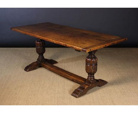 A Small Oak Refectory Table. The rectangular twin plank top with cleated ends resting on two bulbous cup & cover supports car