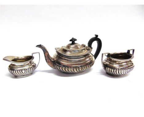 A THREE PIECE SILVER 'BACHELOR' TEA SERVICE Birmingham 1909, of oval gadrooned form, 713g (23 troy ozs) gross