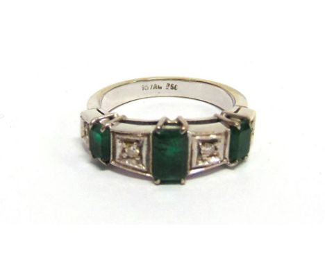 AN EMERALD AND DIAMOND RING the three graduated step cuts with diamonds in between, the white mount stamped '750', finger siz