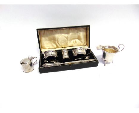 A THREE PIECE SILVER CRUET SET with glass liners, and one silver salt spoon, with a small silver drum mustard pot, with glass