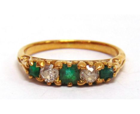 AN EMERALD AND DIAMOND FIVE STONE RING the two old cut diamonds totalling approximately 0.24cts, the unmarked carved head mou