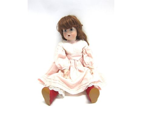 A SIMON & HALBIG FOR KAMMER & REINHARDT BISQUE SOCKET-HEAD DOLL possibly of reproduction vintage, with a long auburn wig, fix