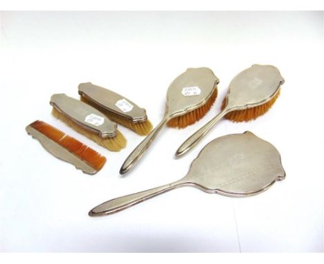 A SIX PIECE SILVER DRESSING TABLE SET  Birmingham 1929, comprising a hand mirror, four brushes and a comb