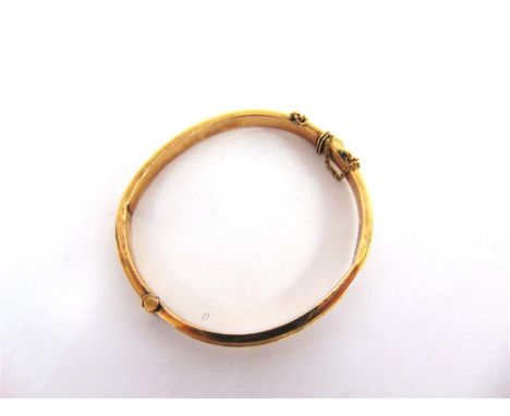 A 9CT GOLD HINGED BANGLE half engraved decoration, 4.7cm inner diameter, 8.9g gross