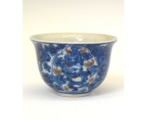 Chinese porcelain blue and iron-red tea bowl, decoated in underglaze blue with two quatrefoil panels of dragons, flames picke