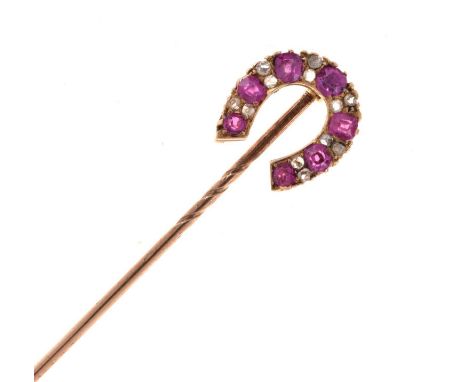 A diamond and ruby horseshoe stick pin, the seven graduated rubies with pairs of rose cut diamonds between, cased