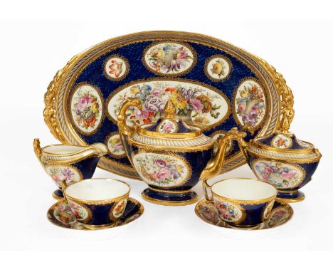 A Coalport Empire style tête-à-tête set, early 19th Century, painted with floral reserves on a blue scale ground, with flying