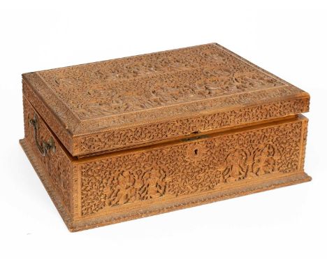 An Anglo-Indian carved sandalwood dressing box, mid 19th Century, the hinged lid enclosing a removable mirror and a fitted tr