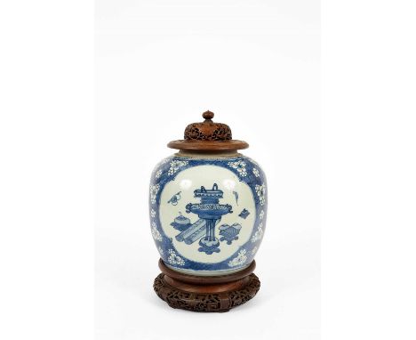 A Chinese blue and white ginger jar, Kangxi, painted with panels of precious objects on a prunus ground, 20cm high excluding 