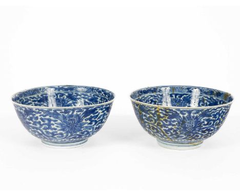 A pair of Chinese blue and white 'Lotus' bowls, Kangxi mark and period, painted in underglaze blue with a central medallion o