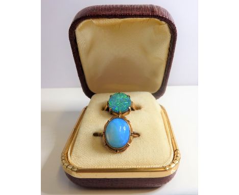 A 9-carat yellow-gold dress ring set with a flat oval opal (ring size O/P), together with one other similar set with a caboch