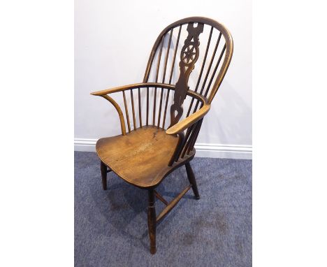 A mid-19th century comb-back Windsor armchair; wheel-back splat, shaped elm saddle-seat and turned tapering slightly splaying