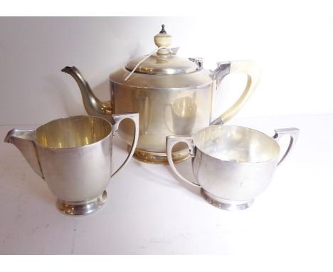 A heavy Art Deco period hallmarked silver three-piece tea service, the teapot with ivory handle and finial, maker's mark EB, 