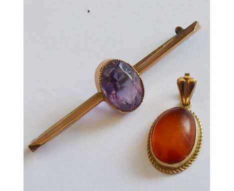 A small 9-carat yellow-gold pendant mounted with an oval cabochon amber together with a 9-carat rose-gold stick pin centrally