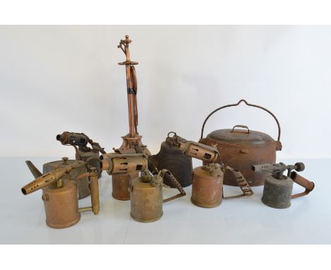 A collection of early 20th Century blow torches, a cast iron road light by Wells Unbreakable, no 1, a Canon cast iron cauldro