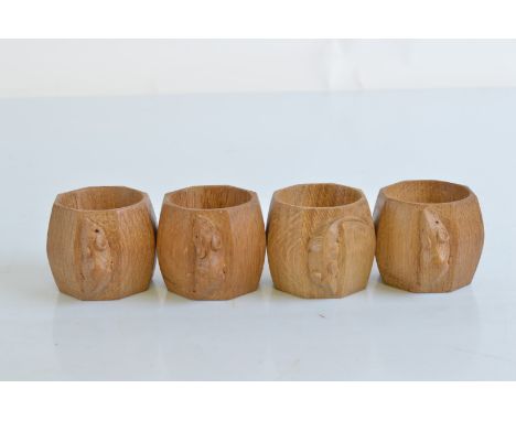 A set of four Robert Thompson Kilburn 'Mouseman' octagonal carved napkin rings, 5cm high x 6cm diameter to include mouse