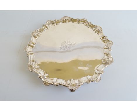 A George III silver salver, with Chippendale shell decorated shaped rim, engraved monogram to centre on three cabriole legs, 