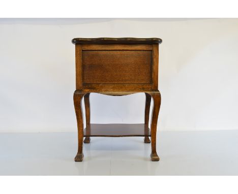 A 1900s stained beech sewing box table, with swivel top revealing fitted interior on shaped legs united by lower tiered shelf