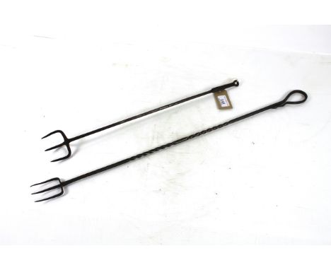 An 18th Century wrought iron triple pronged flesh fork and an early 20th Century wrought iron long handled toasting fork