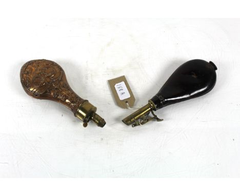 An ornate brass and copper powder flask and a leather and brass powder flask