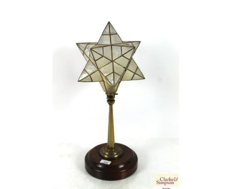 A brass vintage star shaped table lamp on wooden plinth