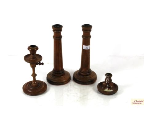 A pair of large antique pine candlesticks, an adjustable fruit wood candlestick and a small oak chamber stick 