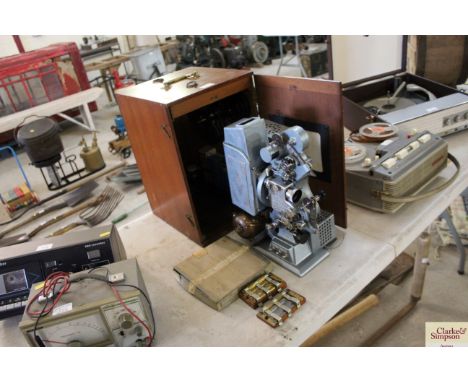 A vintage projector in mahogany case with numerous accessories 