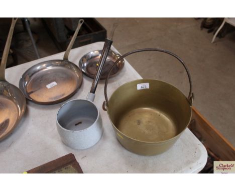 A brass swing handled jam pan and a long handled enamel saucepan