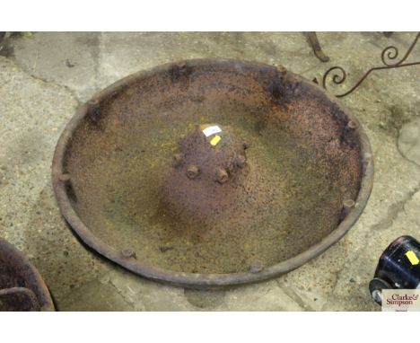 A circular cast iron pig trough missing sections