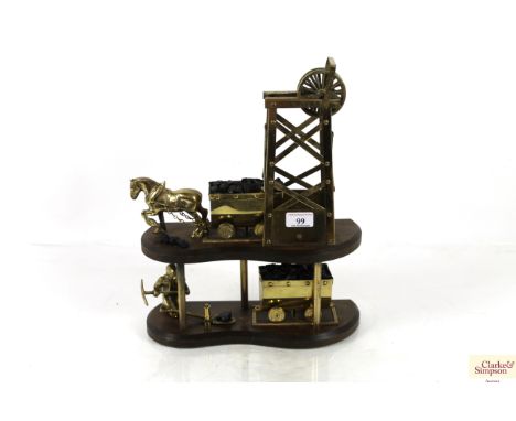 A brass coal mining model on wooden plinth