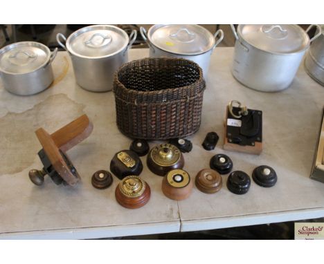 Twelve early vintage bell pushers, two door latches and attachments and a small wicker basket