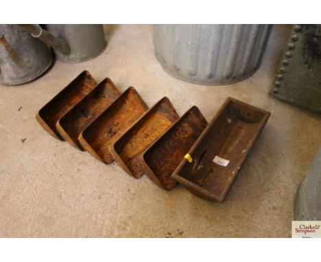 Five small metal wall hanging troughs and a further cast iron trough AF
