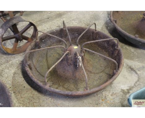 A circular cast iron pig trough with divisions