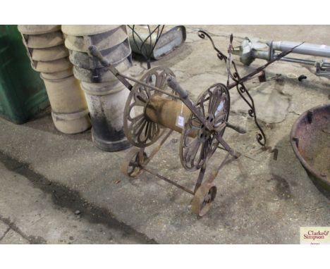A vintage ornate metal hose reel trolley