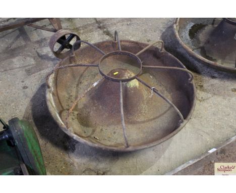 A circular cast iron pig trough with divisions