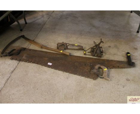Two vintage saws, a slasher and two traps