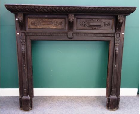 A 17th century style oak fire surround, with gadrooned edge and face mask decoration, 168cm wide x 151cm high, the internal a