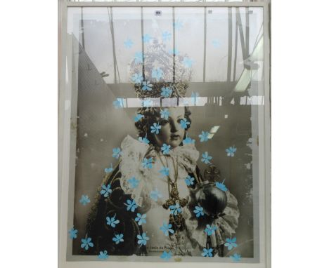A black and white photographic print depicting a porcelain child doll wearing a crown, robes and scepter, over-painted with b