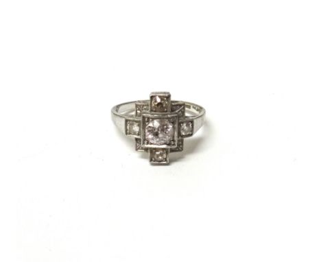 A white gold and platinum, diamond set ring, mounted with the principal cushion shaped diamond at the centre and with four sm